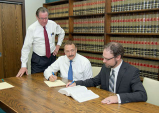 Photo of the firm's attorneys around a conference table
